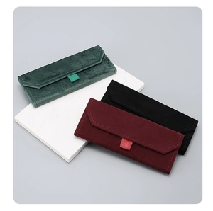 Detail view of foldable velvet glasses cases in dark green, black, and burgundy tones