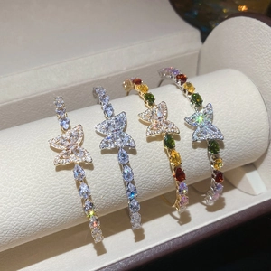 Dettaglio di quattro orecchini a cerchio a farfalla con zirconi colorati e pavé di lusso