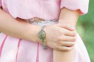 Close-up of a silver stainless steel double-layer bracelet with tree of life charm