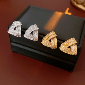 Gros plan de boucles d'oreilles triangulaires avec zircons brillants en finitions or et argent