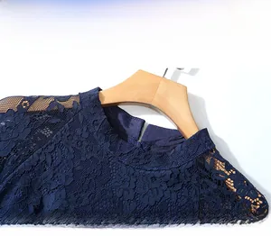 Vue détaillée du tissu en dentelle au crochet bleu foncé et du col montant de la robe