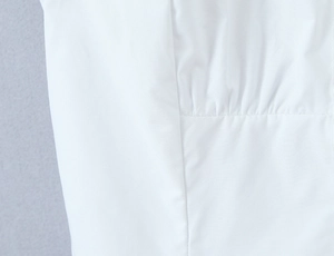 Detailed close-up of white vintage puff sleeve shirt showing fabric texture and pleated seams