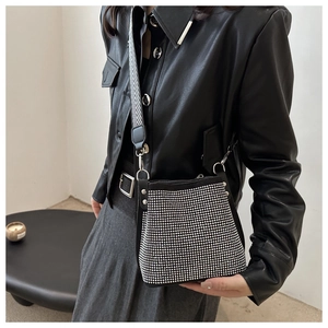 Close-up of black bucket bag with silver rhinestones and a V-stripe wide shoulder strap