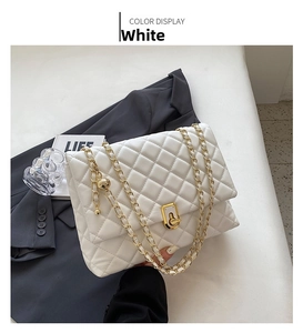 Detail view of the white quilted chain bag with gold metal clasp and interior compartments