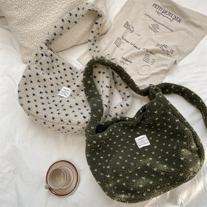 Detail of plush lamb wool tote bags in cream and dark green with polka dot patterns
