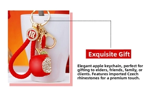 Detail of red apple keychain with sparkling crystals and a golden spring buckle charm