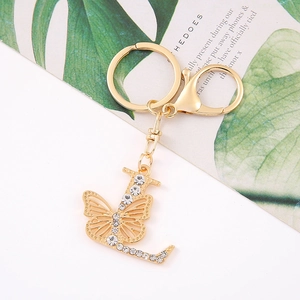 Detail view of golden metal letter L keychain with butterfly and sparkling crystals
