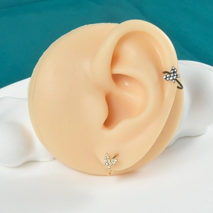 Detail shot of black and gold butterfly ear cuffs with zircons on a model ear