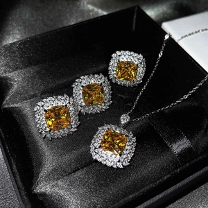 Close-up of luxury yellow gemstone jewelry set with square halo design in a black box