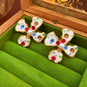 Macro detail of vintage floral earrings with colorful stones and pearls in velvet box