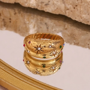 Detail of 18K gold plated dome ring with star carvings and inlaid colorful gemstones