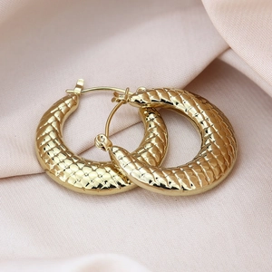 Detailed view of hollow gold-plated chunky hoop earrings with textured scale pattern