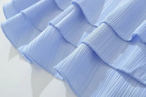 Détail de volants bleu clair avec texture plissée verticale et finitions de couture soignées