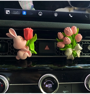 Detail of pink rabbit and tulip car aroma stone diffusers clipped on air vent