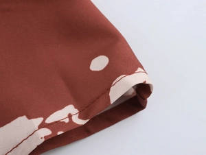 Vue macro d'un tissu tissé marron à imprimé floral blanc et couture d'ourlet détaillée