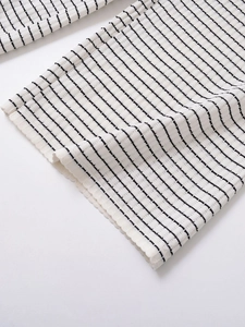 Gros plan détaillé montrant la texture douce et les rayures noires et blanches du tricoté