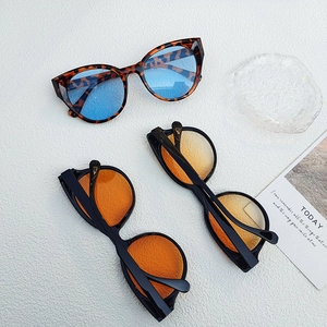 Detailed view of cat eye sunglasses in leopard print and varied lens colors on a tray