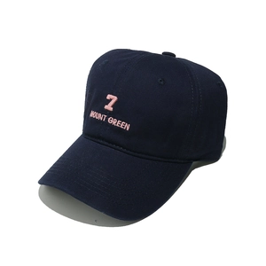Detail of navy blue baseball cap featuring pink '7' and 'MOUNT GREEN' embroidery