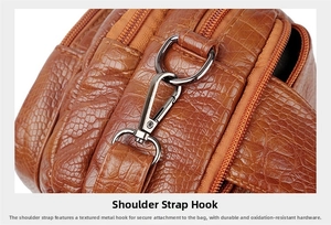 Détail du crochet de sangle en métal gris foncé sur sac brun motif crocodile