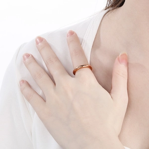 Detailed view of an 18k rose gold plated titanium steel ring worn on model skin