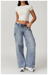 Slim fit white athletic short sleeve crop top paired with distressed wide leg denim jeans