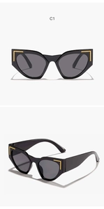 Detail view of oversized cat-eye sunglasses with thick black frames and gold L-shaped accents