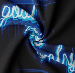 Detail of soft black knit tapestry with vibrant blue neon art print and smooth texture