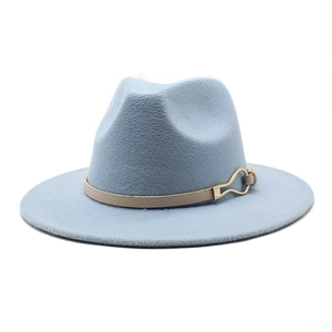 Détail du chapeau fedora bleu clair en laine avec ruban beige et boucle dorée en goutte