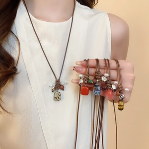 Detailed view of ethnic wax cord necklaces with colorful natural stone and wood bead pendants