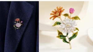 Detail of colorful floral brooch on blue blazer and close-up on white dish