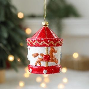 Carousel Christmas ornament with red and gold details hanging on a decorated tree