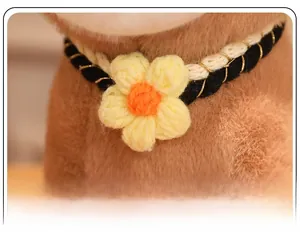 Macro detail of a handmade knit pet collar with a yellow flower and woven gold thread