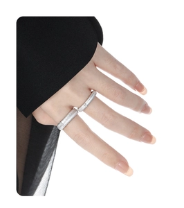 Detail of silver brushed rings on hand featuring textured design and small crystal accent