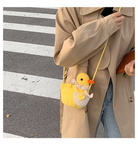 Detail of handmade crochet yellow duck crossbody bag with knitted texture and strap