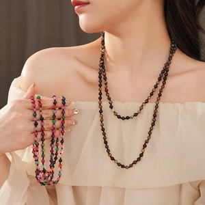 Detail of bohemian agate round pendant necklace worn on neck with colorful beaded strands