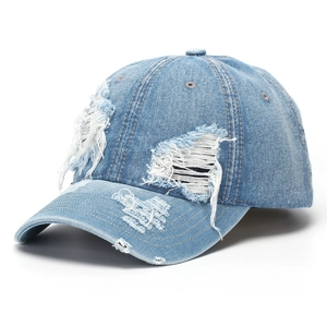 Détail d'une casquette de baseball en jean délavé avec design vintage à trous