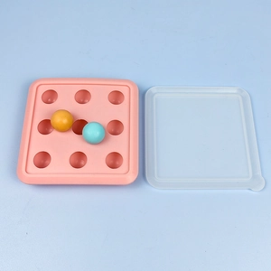 Pink 9-cavity silicone ice cube tray with clear lid and colorful round ice spheres
