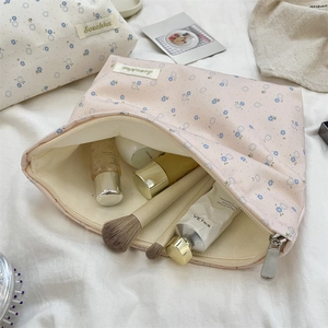 Detailed view of floral makeup bags with zip closure and spacious beige canvas interior