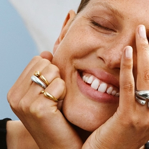 Fashionable titanium steel open rings in gold and silver finish worn by a smiling model