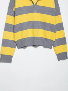 Détail du pull en maille rayé jaune et gris avec un col polo en V et manches longues