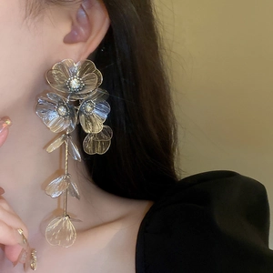 Detail of silver long tassel flower earrings with rhinestones on a model's profile