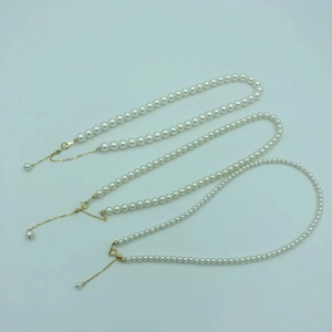 Detailed view of three white pearl necklaces with adjustable 14k gold-filled clasps