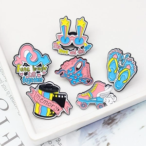 Set of 6 colorful enamel pins including 3D glasses, skates, and flip flops in a tray