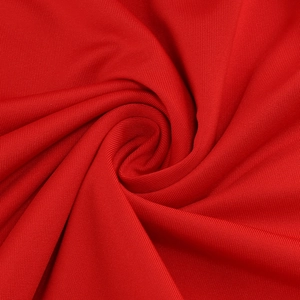 Macro shot of red bandage dress fabric showing soft spiral texture and fine knit detail