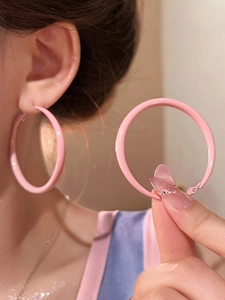 Detail of pink cherry blossom enamel hoop earrings shown with elegant skin tone contrast