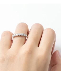 Close-up of a 925 sterling silver seven-stone row ring with moissanite on a finger
