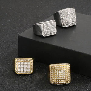 Dettaglio di anelli quadrati hip hop in oro e argento con strass bianchi luccicanti