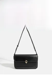 Detail of black matte leather shoulder bag with gold metal clasp and stitching