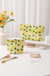 Detail of quilted jacquard makeup bags with blue floral pattern and H&R logo tag