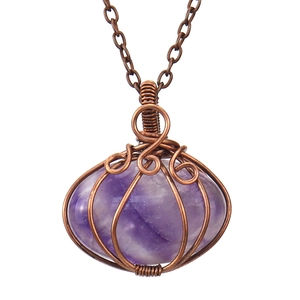 Detail of handmade copper wire-wrapped amethyst crystal pumpkin pendant on necklace